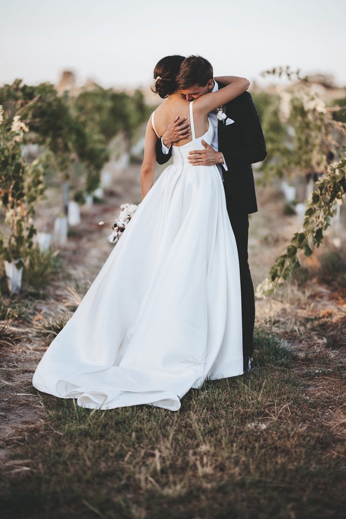Groom Hugging Bride Wearing Square Back Satin Wedding Dress Called Selena by Maggie Sottero at Vineyard Wedding