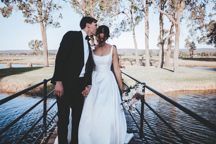 Groom Walking with Bride Wearing Modern Satin Wedding Gown by Maggie Sottero at Vineyard Wedding