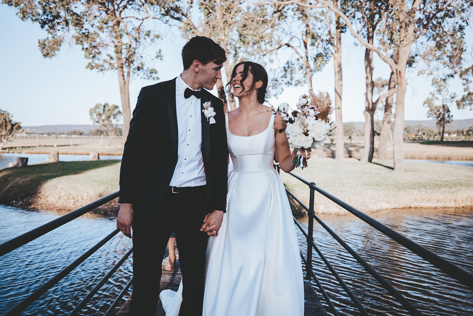 Groom Walking with Bride Wearing Modern Satin Wedding Gown by Maggie Sottero at Vineyard Wedding