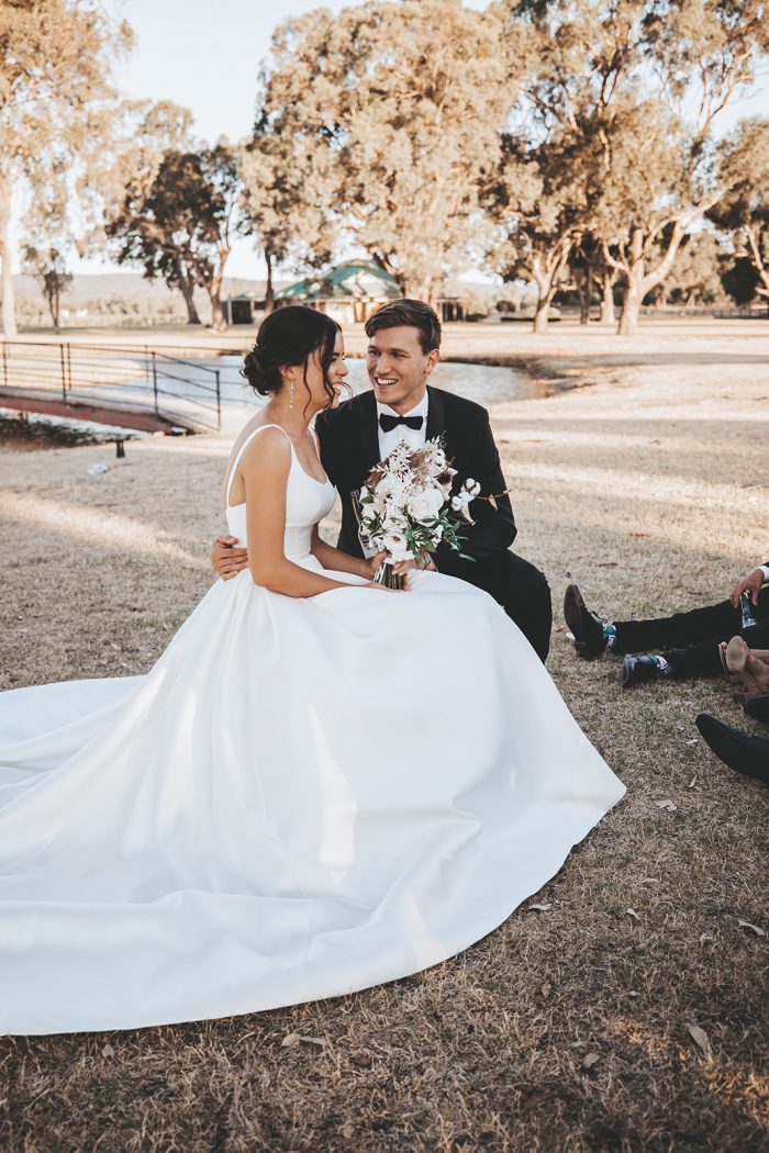 Groom Sitting with Bride Wearing Satin Ball Gown Wedding Dress Called Selena by Maggie Sottero