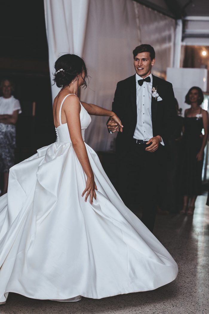 Groom Dancing with Bride Wearing Modern Satin Wedding Gown Called Selena by Maggie Sottero