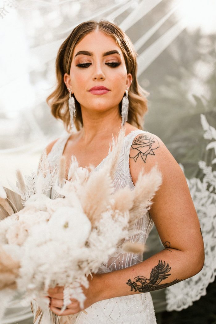 Real Bride Wearing Maggie Sottero Wedding Dress and Holding Modern White Wedding Bouquet