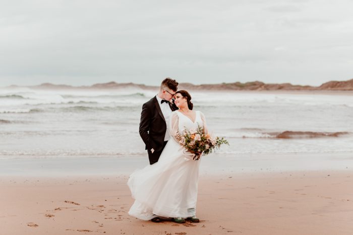Bride In Romantic A Line Wedding Dress With Bishop Sleeves On Beach Called Joanne By Rebecca Ingram