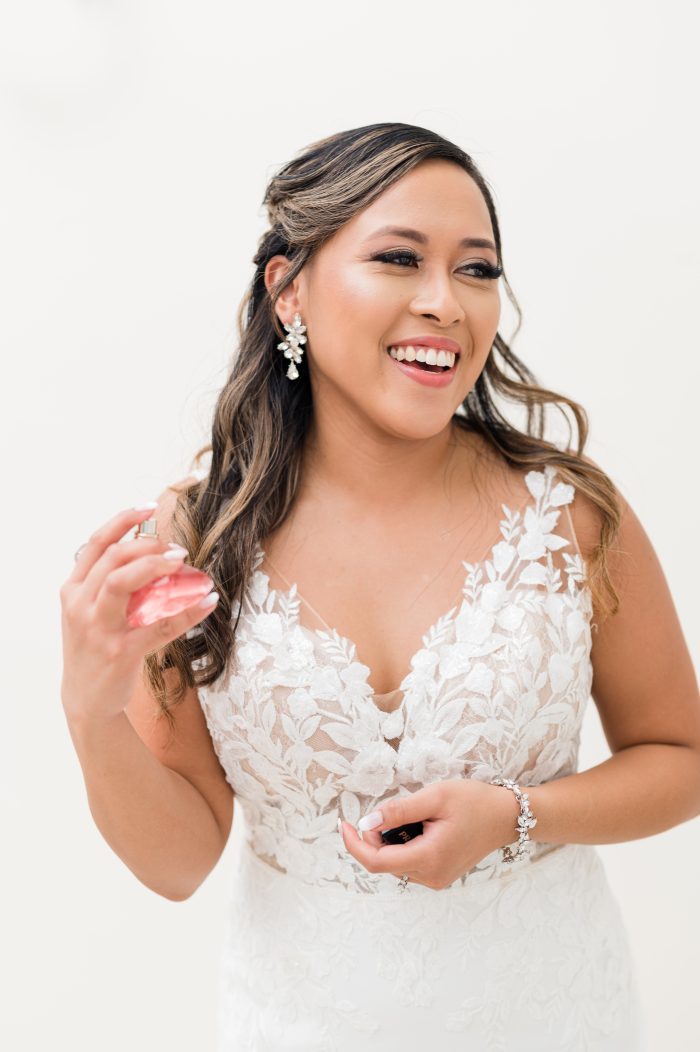Bride wearing Baxley by Maggie Sottero putting on perfume as a new wedding tradition