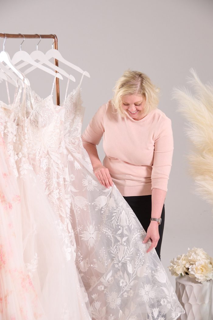Seamstress inspecting a wedding dress for alterations