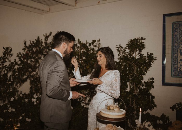 Bride wearing Drita by Maggie Sottero doing the first bite of wedding cake wedding tradition with her husband