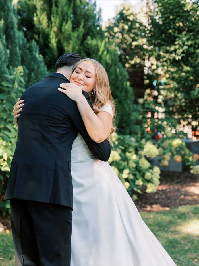 Bride wearing Ekaterina wedding dress by Maggie Sottero does a first look with her husband as a new wedding tradition