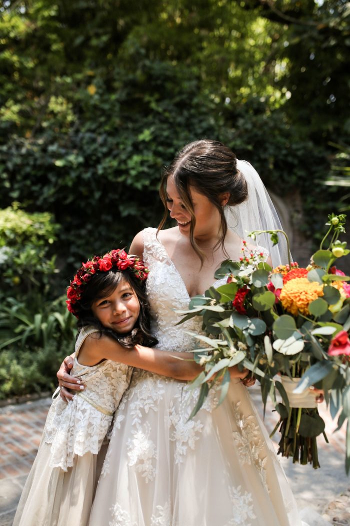 Real Bride at Destination Wedding in Mexico Hugging Little Mexican Flower Girl