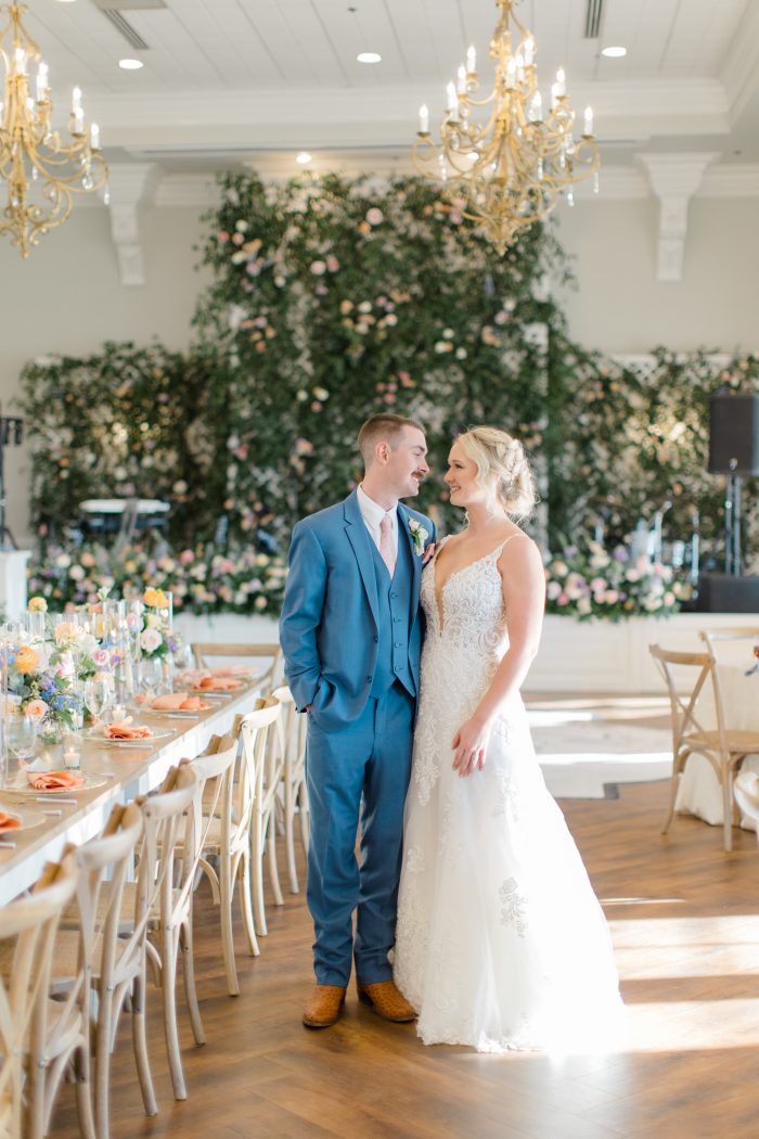Bride wearing Johanna wedding dress by Maggie Sottero with her husband in their reception hall.