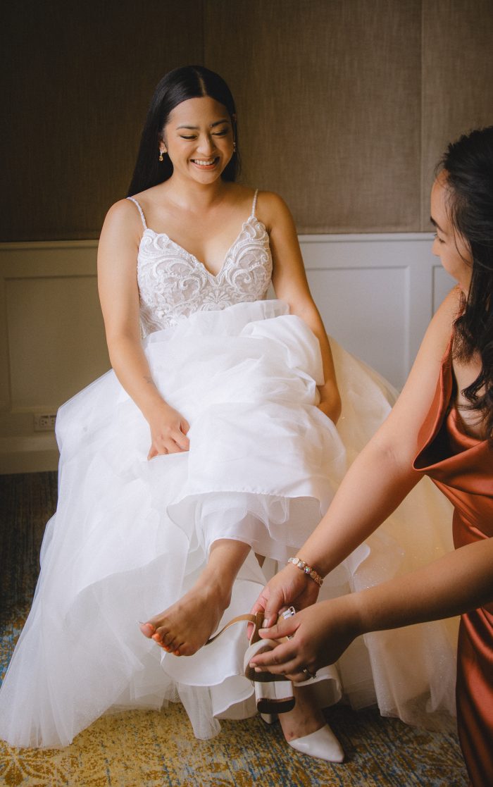 Sister putting on the bride's shoes