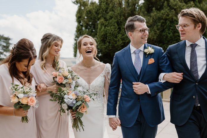 Bride wearing Nikki wedding dress by Maggie Sottero and holding hands with her husband.