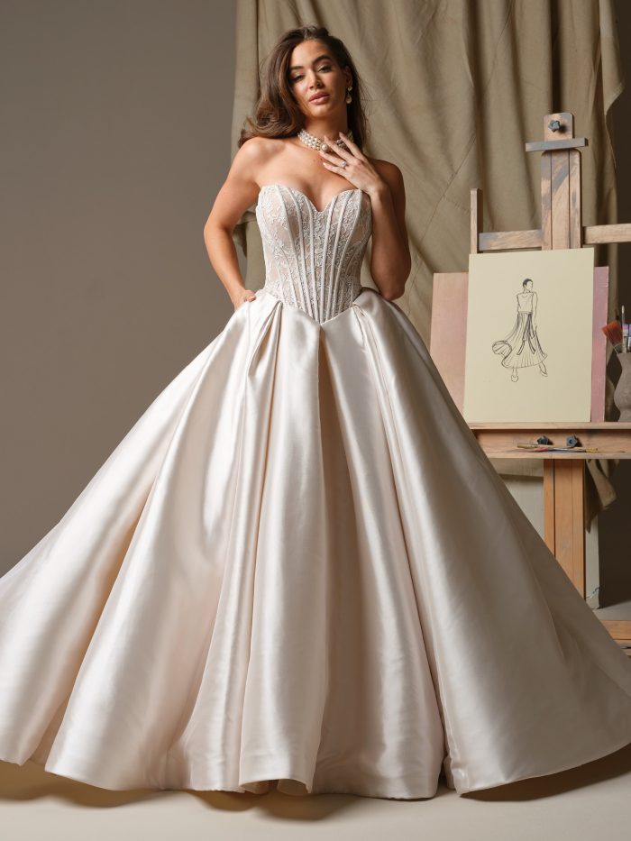 Bride wearing the Ashland ballgown wedding dress featuring a strapless sweetheart neckline, floral lace corset bodice with exposed boning, and a full satin ballgown skirt with dramatic volume, photographed in a studio setting.