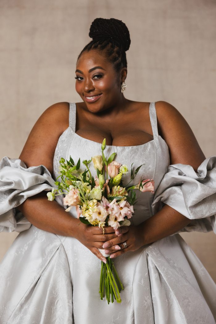 Plus size bride holding a bouquet of flowers feeling confident