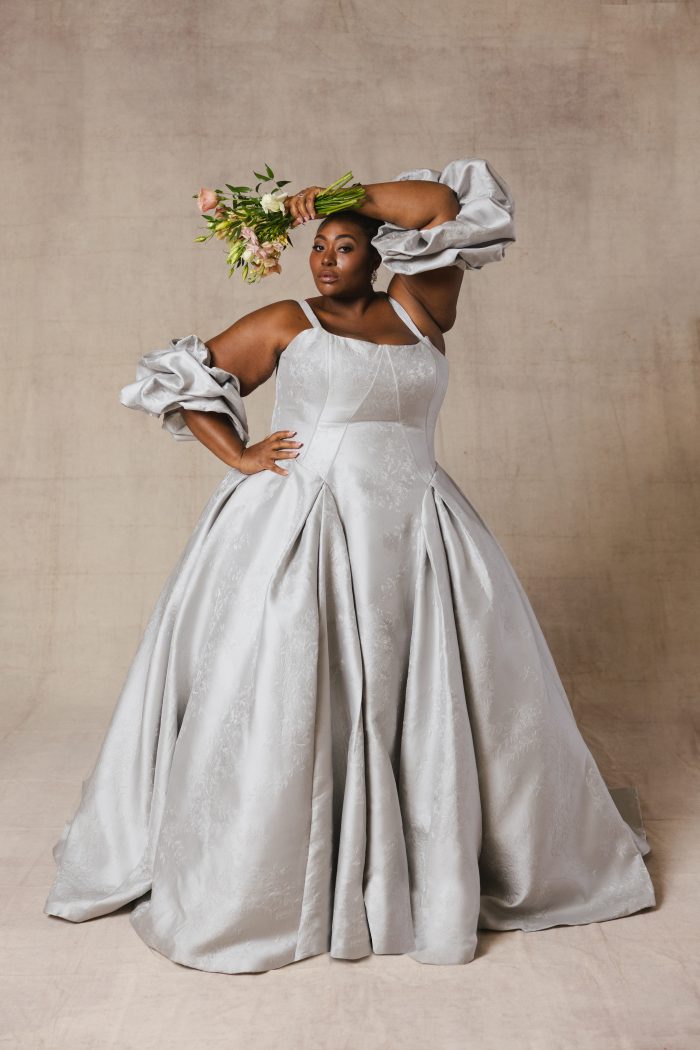 Plus size bride wearing a blue satin ballgown wedding dress with arm bands and tank straps