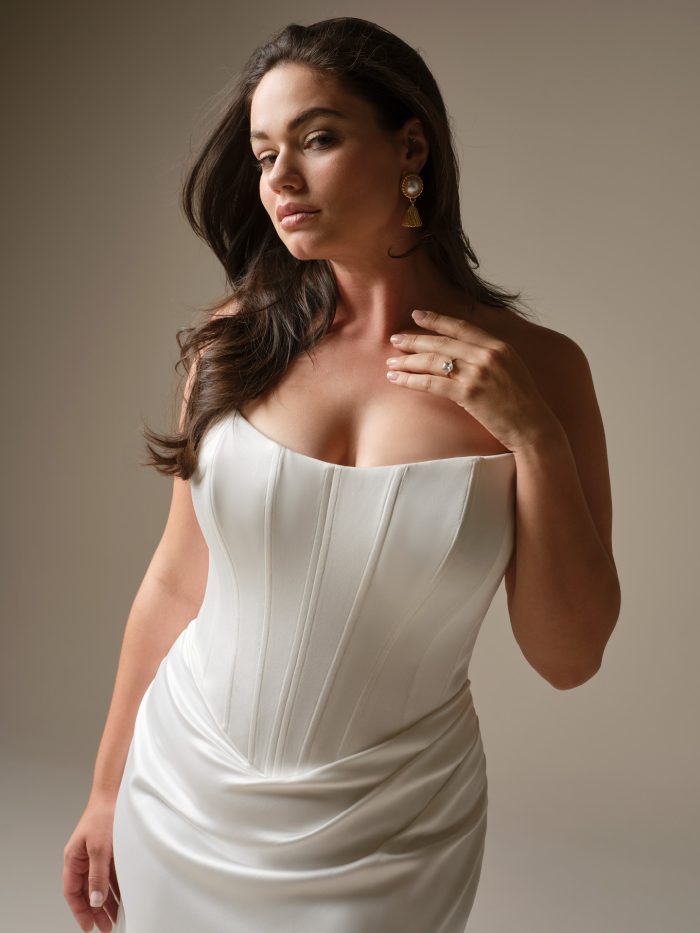 Close-up of Sinclaire by Maggie Sottero wedding dress featuring a satin corset bodice with exposed boning and a strapless neckline