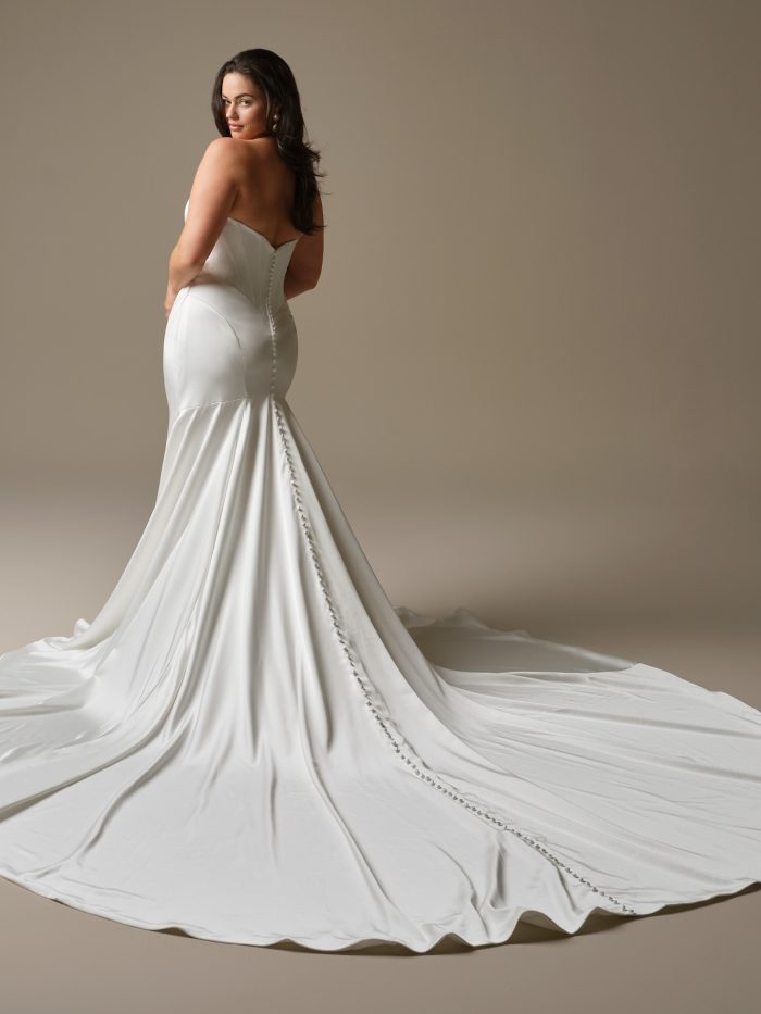 Back view of Sinclaire by Maggie Sottero featuring a strapless satin fit-and-flare silhouette with covered buttons trailing down the train.
