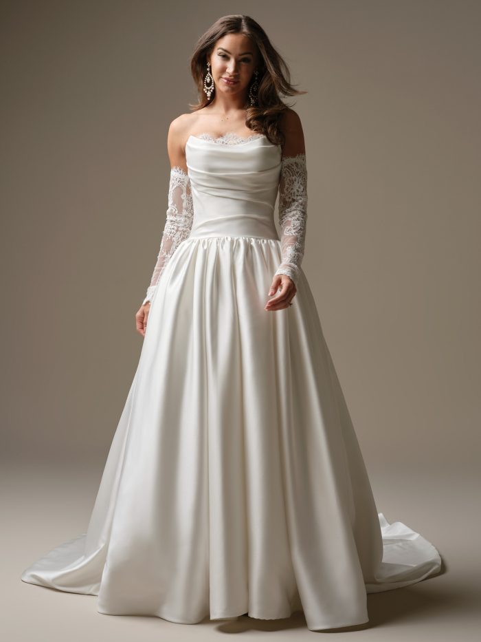 Maggie Sottero Sylvana ballgown wedding dress featuring a strapless draped satin bodice, lace-trimmed neckline, detachable illusion lace sleeves, and a full flowing skirt with subtle train.