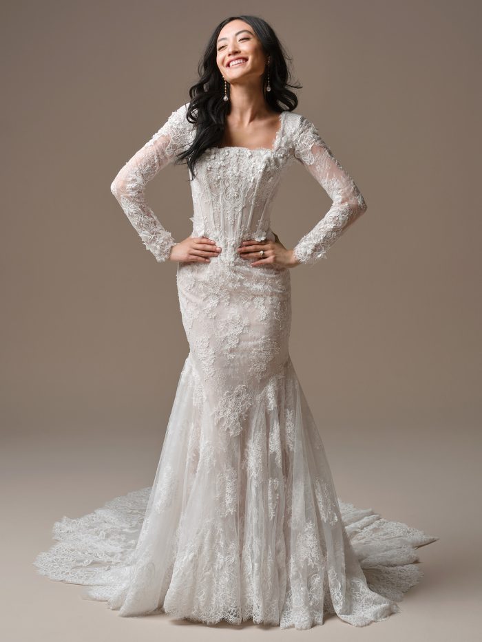 Maggie Sottero Takera Leigh wedding dress featuring a long-sleeve lace fit-and-flare silhouette with dimensional floral detailing and a chapel train.