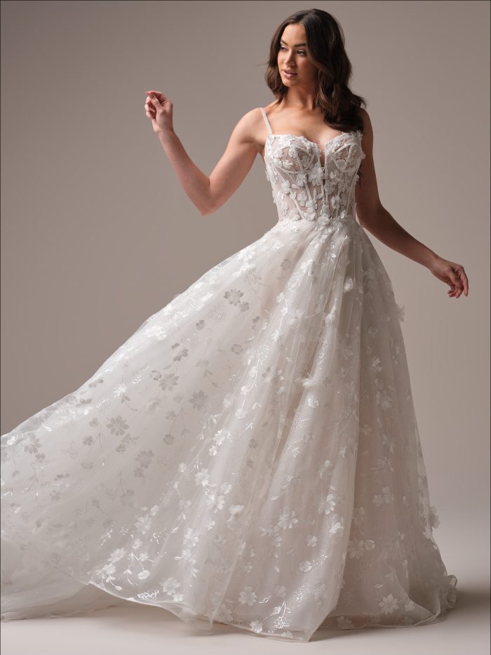 Bride wearing the Wallis A-line wedding dress featuring shimmering floral lace, a softly flowing tulle skirt with subtle sparkle, and a romantic silhouette that moves beautifully with every step.