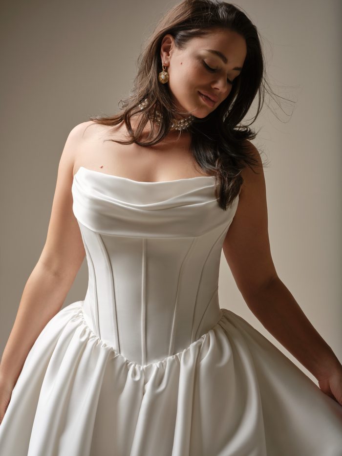 Close-up of the Yuma wedding dress showing the draped strapless neckline and structured corset bodice with clean seaming.