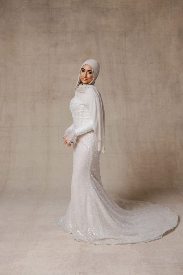 Muslim bride wearing a head scarf and a sequin fit and flare wedding dress