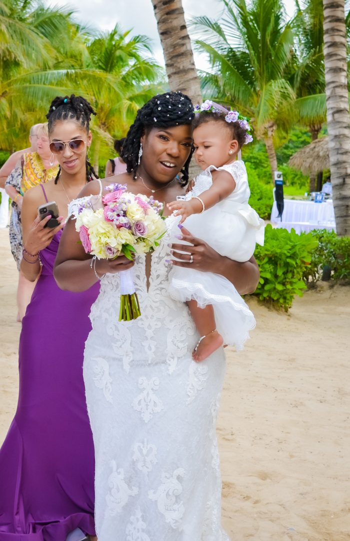 Bride wearing Tuscany Royale by Maggie Sottero holding a flower girl