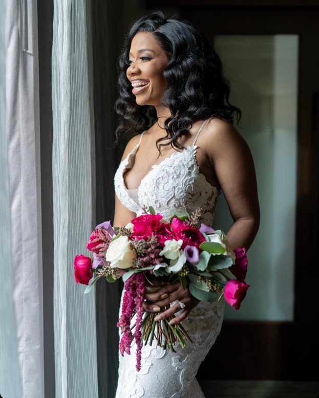 Real Bride holding her purple flower bouquet wearing Tuscany Lynette Lace Mermaid Wedding Gown by Maggie Sottero