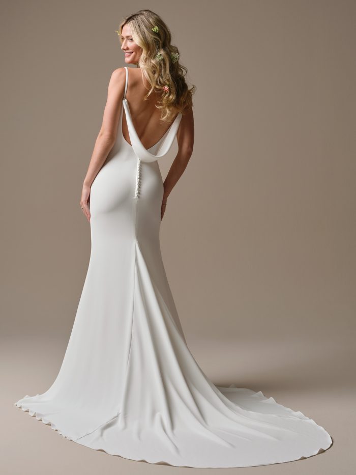 Back view of the Brenda sheath wedding dress highlighting the low draped cowl back, covered button detail, and the sleek, figure-skimming crepe skirt.