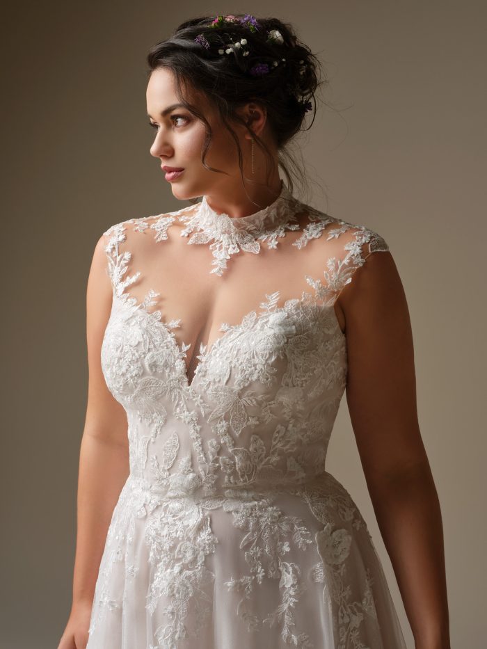 Rebecca Ingram Cody wedding gown featuring floral lace appliqués, plunging illusion neckline, and flowing A-line silhouette
