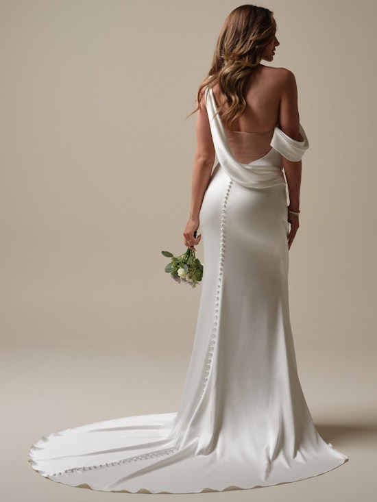 Bride holding a flower bouquet with an open back wedding dress