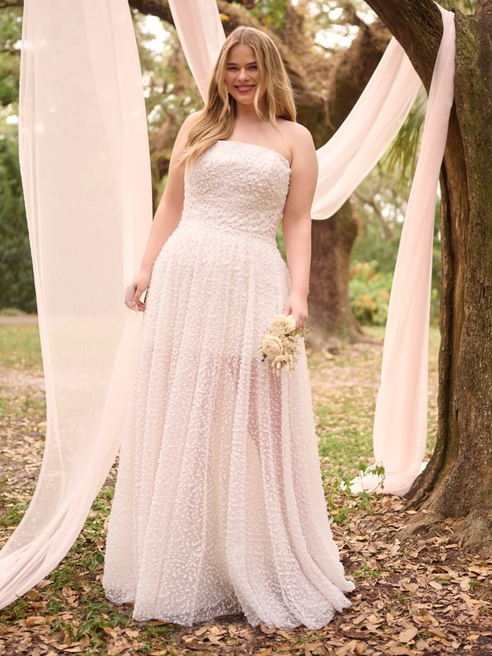 Bride wearing the Taylor wedding dress with the matching detachable overskirt, featuring a strapless beaded bodice and a soft, airy A-line skirt for a romantic layered look.