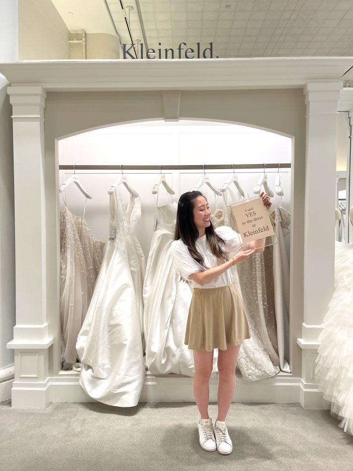 A real bride holding a say yes to the dress sign