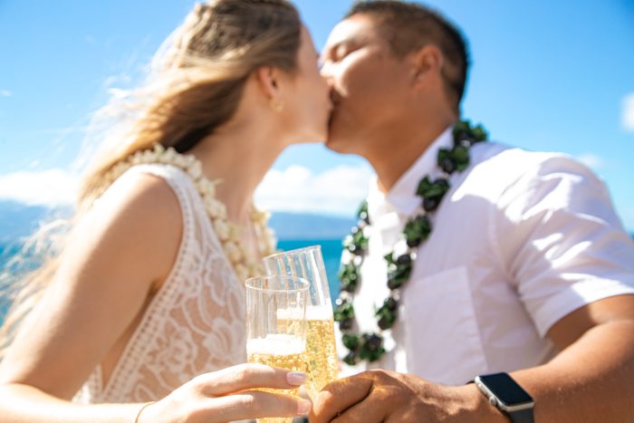 Bride and Groom Kissing and Clinking Glasses of Champagne