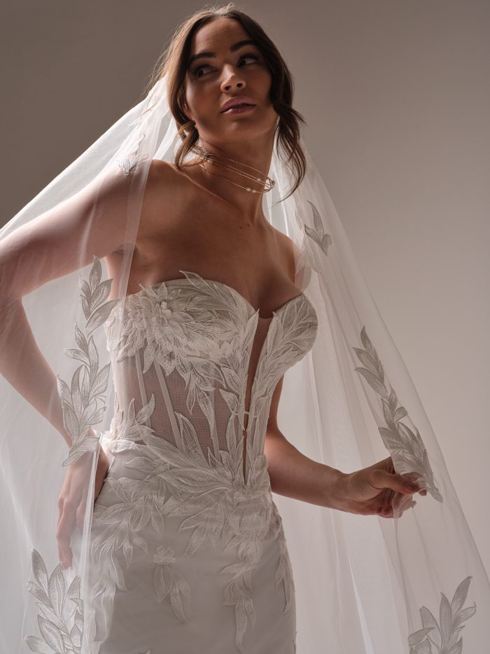 Close-up of the Belladonna wedding dress bodice featuring sheer illusion corset construction, floral lace appliqués, and plunging neckline