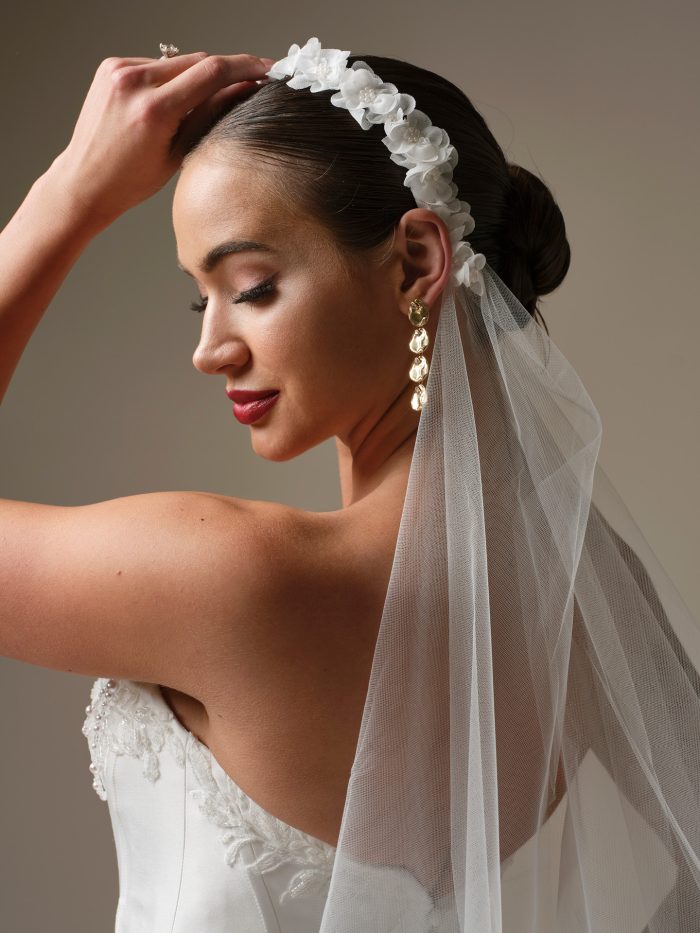 Bride wearing the Kalinda veil by Sottero and Midgley, featuring a 3D floral headband detail with soft tulle draping from the crown.