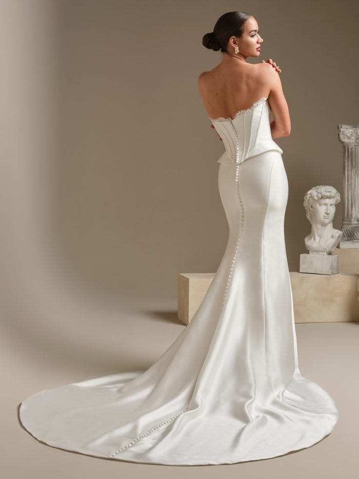 Back view of the Lassen Marie two-piece wedding gown showing the structured strapless corset bodice, button-down detailing, and a sleek fitted skirt flowing into a long train.