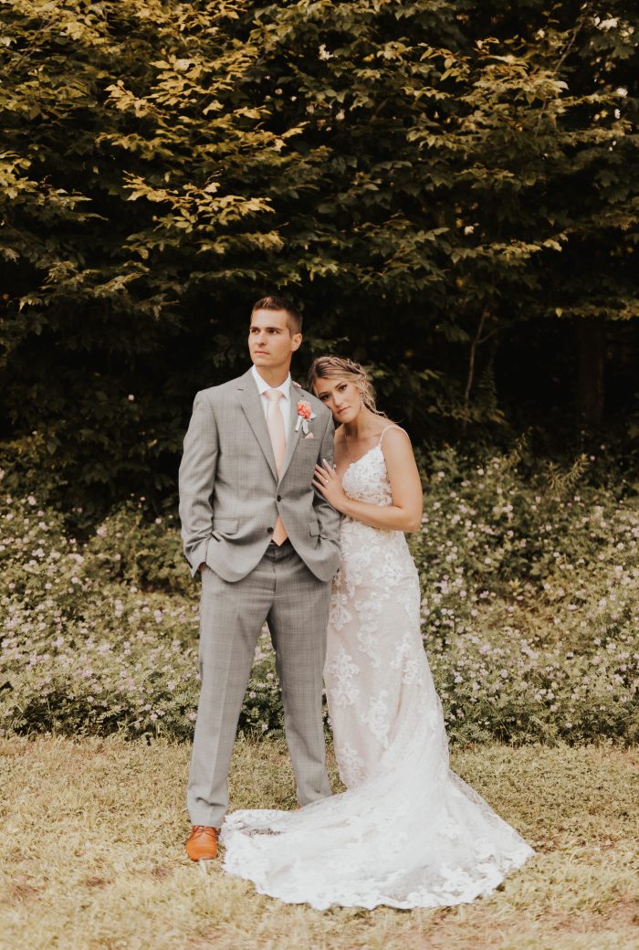 Bride wearing Tuscany Lynette wedding dress by Maggie Sottero with her husband, who is wearing a peach fuzz tie.