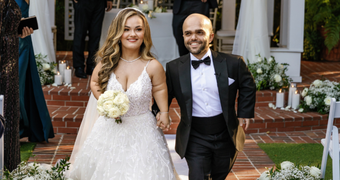 Lona in an A-line wedding dress with her husband, Sam, on their wedding day.