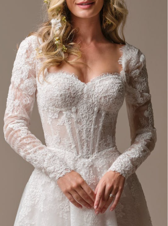 Detachable lace bridal sleeves by Maggie Sottero, featuring illusion lace fabric with floral embroidery, fitted design, and scalloped cuffs paired with a sweetheart corset bodice.